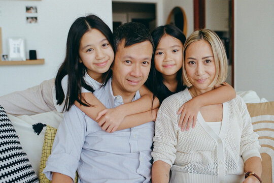 Family of four at home on a sofa 