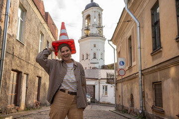 female tourist holding road cone on head