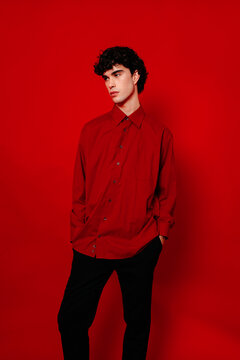 Stylish man in trendy shirt and pants over red background