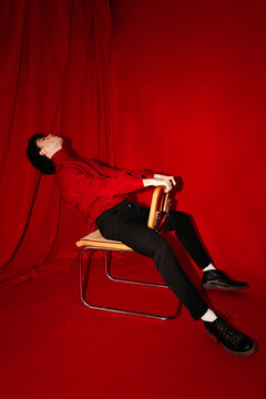 Stylish male model sitting on chair in studio