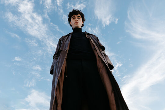 Stylish young male in high neck sweater and trench coat long