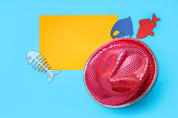 Blank card with paper fishes and hat on blue background. April Fools Day celebration