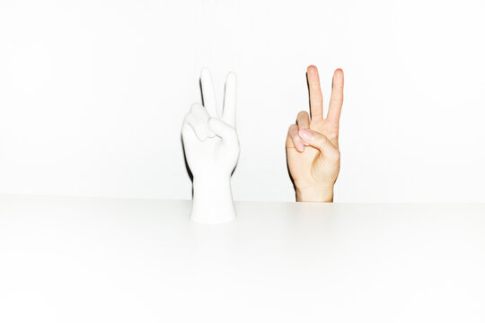 Authentic photo of hand and porcelain statue showing peace signs