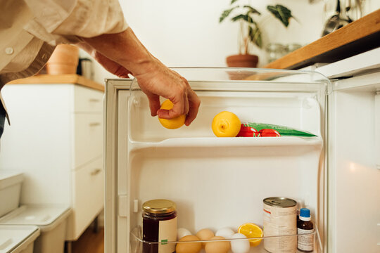Man taking lemon from fridge