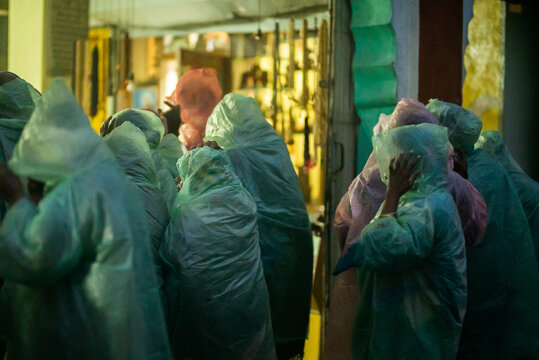 unrecognizable people cover themselves from the rain 