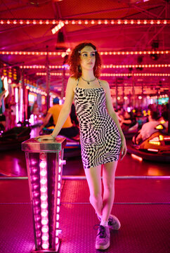 Portrait of a young girl in front of bumper cars at a fair