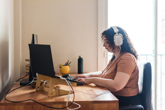 Plus size woman with headphones home office
