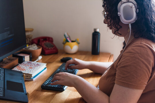 Woman with headphones working on laptop