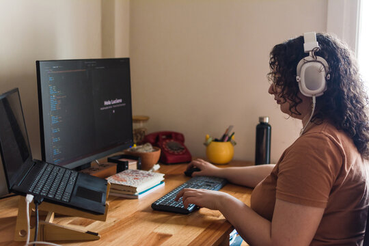 Woman coding at home office desk