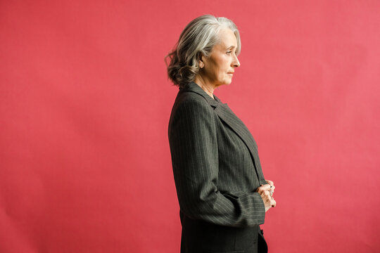 Serious aged woman in grey outfit 