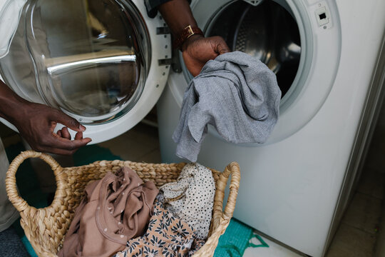 Man putting clothes into into the drum of a washing machine