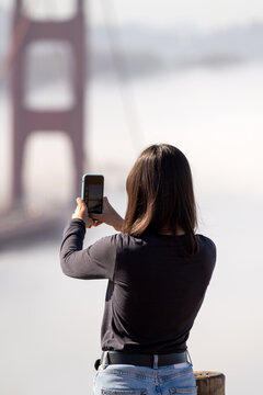 Tourist woman Taking A photo of Golden Gate Bridge