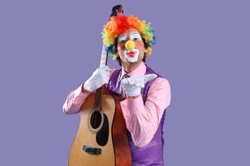 Portrait of clown with guitar blowing kiss on lilac background. April Fool's day celebration