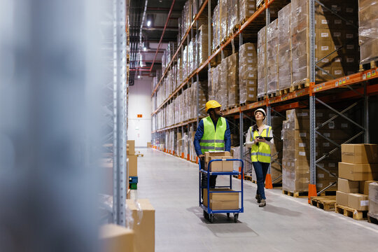 Team warehouse managers walking warehouse aisle
