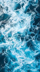 Naklejka premium A close up shot of electric blue water with wind waves crashing on rocks, creating a mesmerizing pattern under the cloudy sky