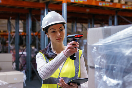 Distribution center worker scanning goods warehouse aisle