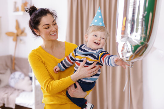 Tot home party balloon caregiver supervise festivity giggle chubby 