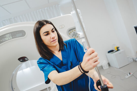 Young woman doctor standing with saline bottle stand