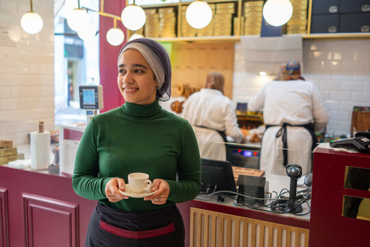 Muslim Cashier Posing in front of the Kitchen