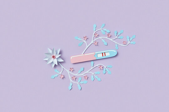 Positive pregnancy test made of colorful paper on purple background