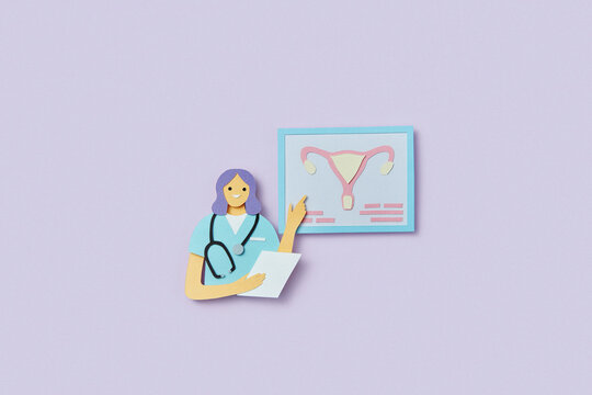 Papercraft composition of gynecologist pointing on female uterus