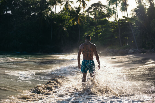 Young man bathing in the Caribbean Sea on an exotic beach