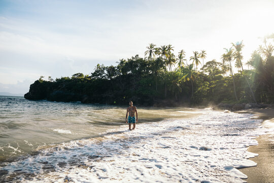 Young man bathing in the Caribbean Sea on an exotic beach