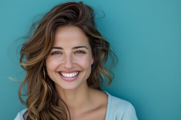 A woman is smiling with her hair blowing in the wind
