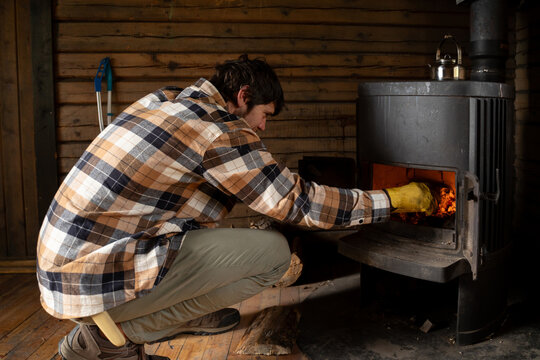Man starting fire at wood stove