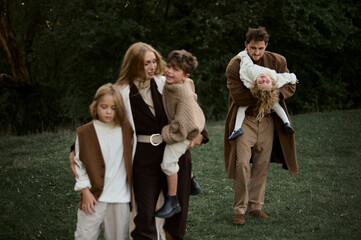 cute family in retro style walking in a green lawn