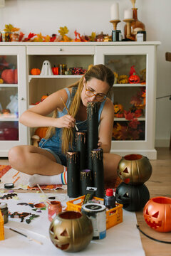 Woman paiting plastic candles for Halloween