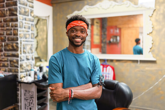 A smiling adult barber at work, looking at camera.