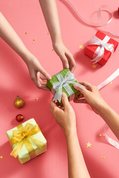 Female hands holding present give to other on decorated background
