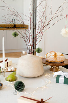 Ceramic vase with branches decorated with Christmas toys
