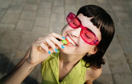 Playfully eating strawberry gummies