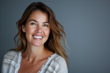 Fototapeta premium A woman with long brown hair is smiling for the camera