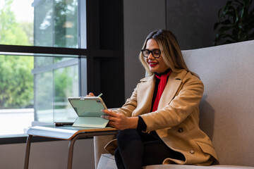 Confident Businesswoman draws on tablet computer cell phone