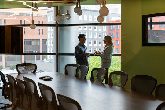 Businesswoman talking with Businessman 
in downtown office in city 