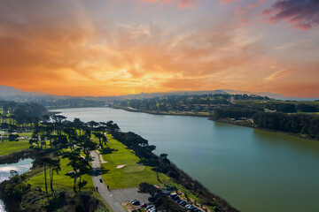 aerial shot of a beautiful spring landscape at Lake Merced with blue lake water and lush green...
