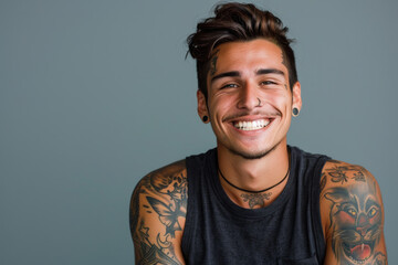 A man with a lot of tattoos on his arms is smiling - obrazy, fototapety, plakaty