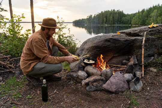 man cooking at bonfire