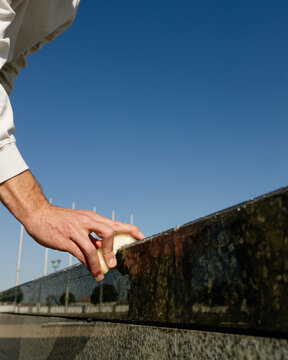 A man's hand puts grease on the parapet