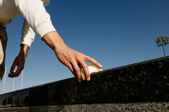 A man's hand puts grease on the parapet