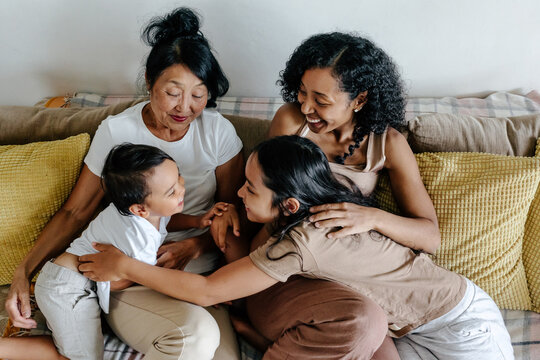 Senior woman with adult daughter and grandchildren on couch