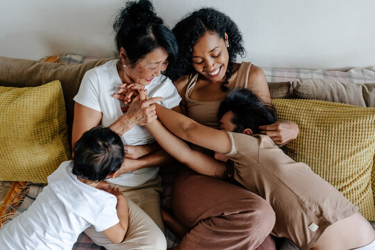 Family romping on couch at home