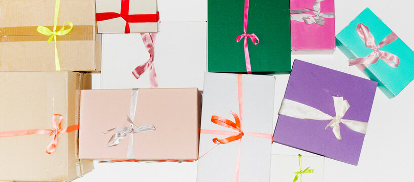 Colourful cardboard Christmas presents and red silk ribbons