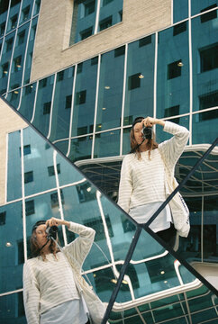 Young woman making photo in a mirror