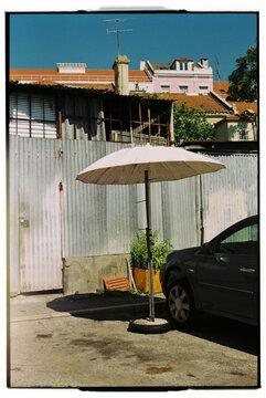 Lisbon street with sunshade umbrella and car parked 