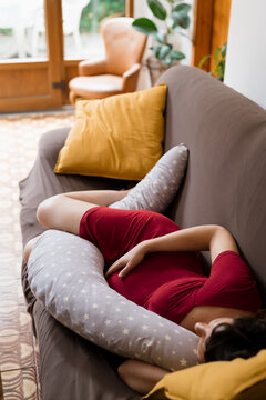 A pregnant woman sleeping on the sofa in the afternoon at home