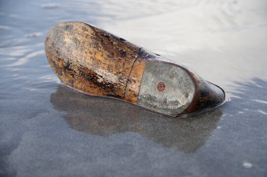 Wood and metal shoe washed up on the shore 
